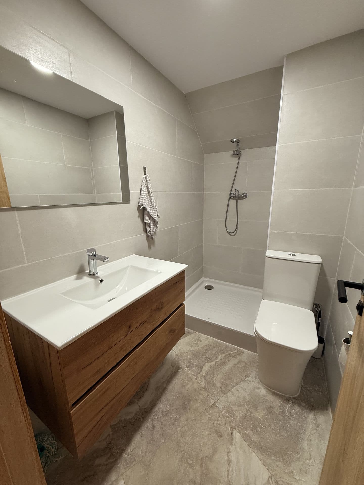 Shared bathroom at CoWork Altea, with a walk-in shower and a wall-mounted sink