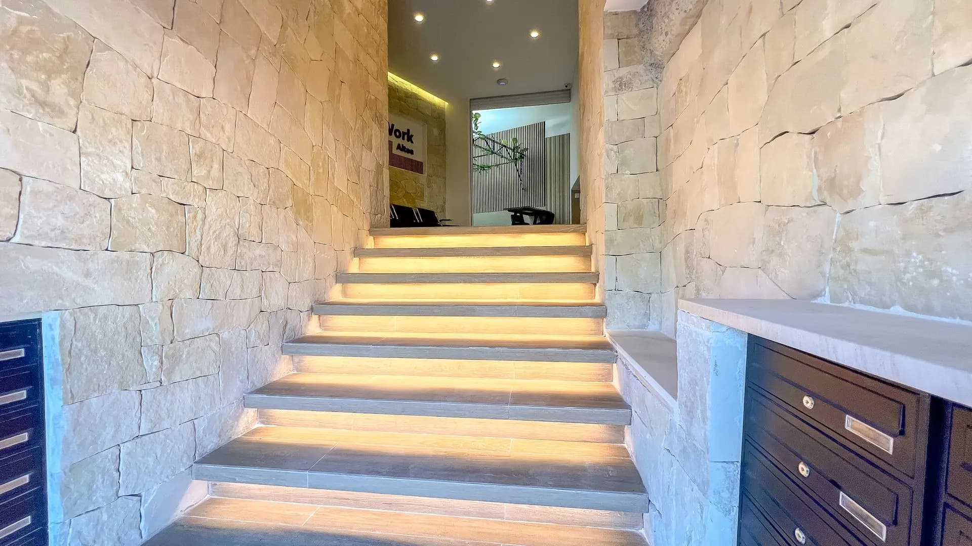 Lit stone staircase at the entrance to CoWork Altea