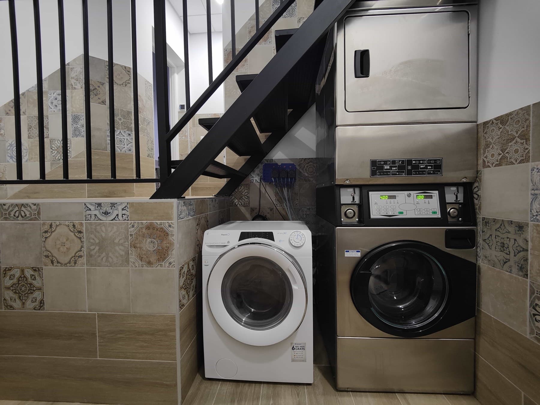 Pueblo Mar's shared laundry room, tucked under the stairs, with coin-operated machines