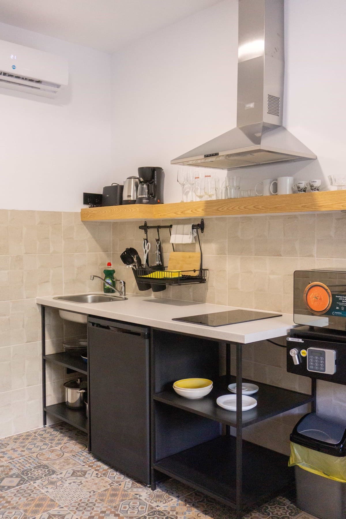 The kitchenette in a La Ruta studio, with a hob, sink, mini-fridge and an in-room safe